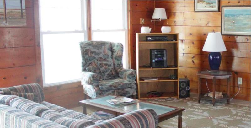 Căn phòng sử dụng gỗ ốp tường cũ kỹ kết hợp với nội thất họa tiết không ăn nhập tạo nên tổng thể lộn xộn. phòng khách cũ kỹ